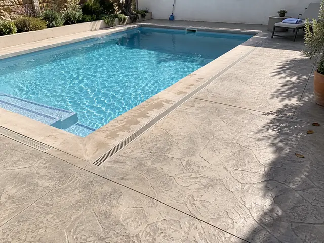 Pavimento de hormigón impreso alrededor de una piscina residencial